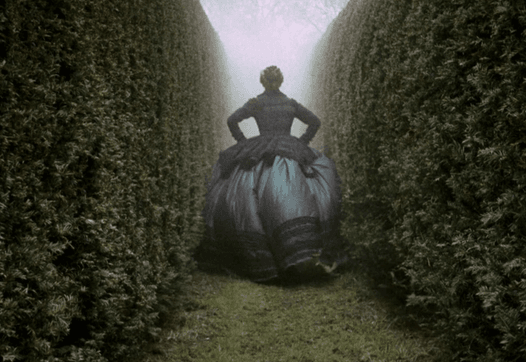 Orlando rent door het doolhof in donkerblauwe jurk