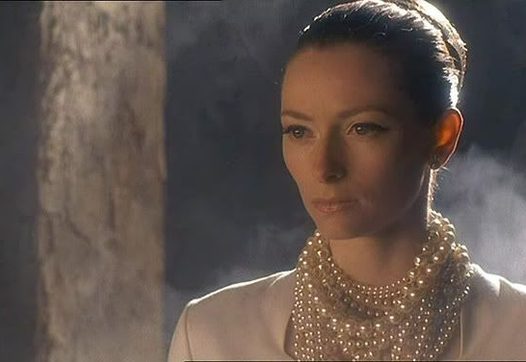 Tilda Swinton als koningin Isabella, ze kijkt langs de camera