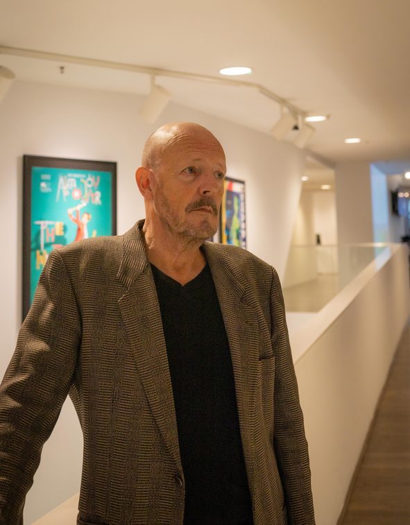 Jaap Bollee poseert voor de affichegalerij in Eye Filmmuseum