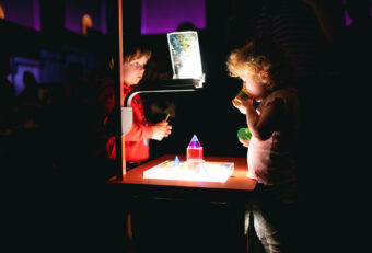 Toddlers play with light boxes during Cinemini