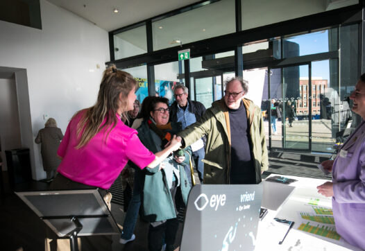 Bij de gastenbalie tijdens een Eye Scoiety evenement worden leden verwelkomt door medewerkers van Eye