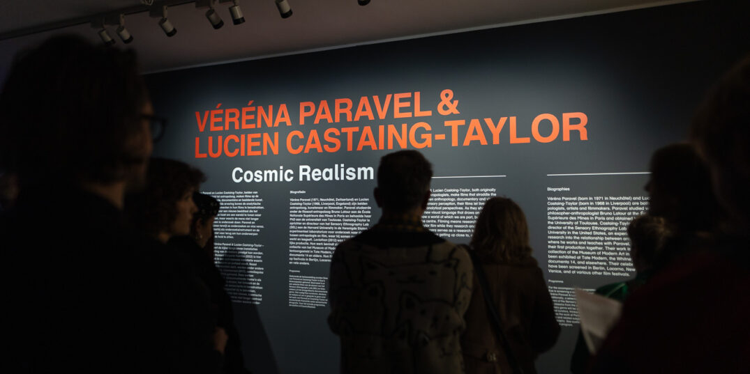 Bezoekers tijdens de opening van de tentoonstelling lezen de zaaltekst