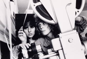 In een foto van Bertien van ﻿Manen uit de jaren '70 controleren Angela Leerkes (l) en Nicolaine den Breejen (r) de analoge film in een filmprojector